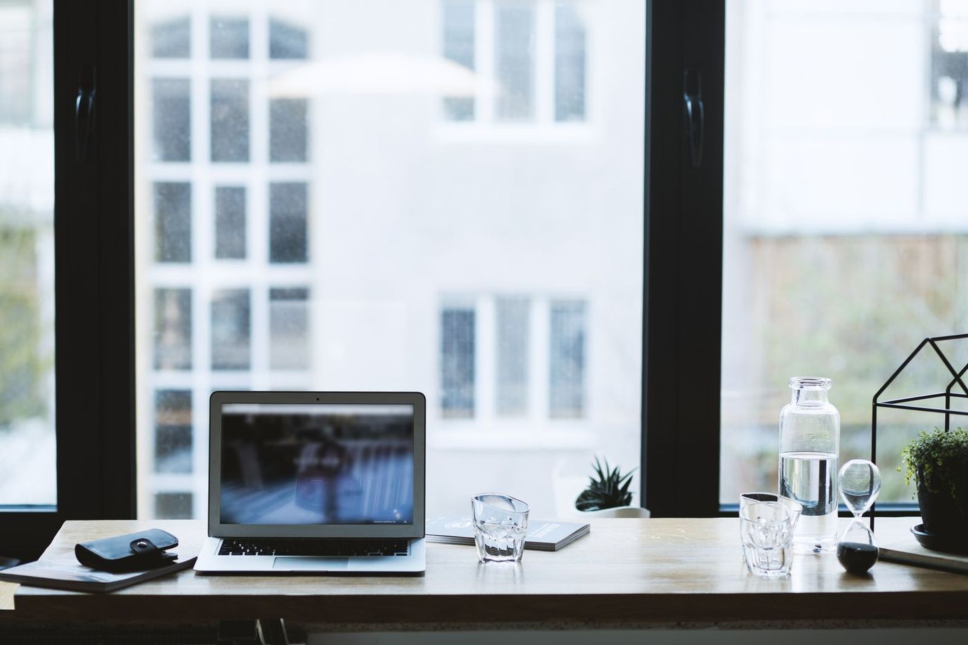 Clean, sunlit office desk beside a large window